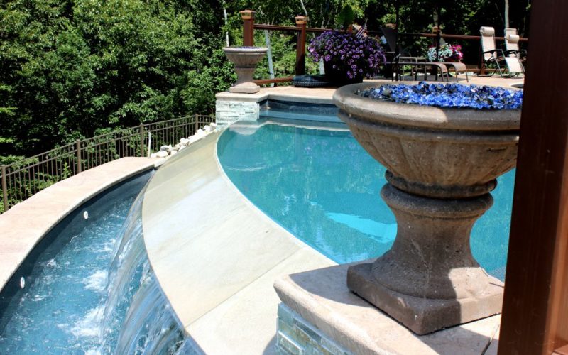 Close up of a custom pool with overflow waterfall installed by Majestic Pools