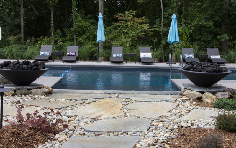 This is a photo of a patrician in ground pool with custom fire pits.