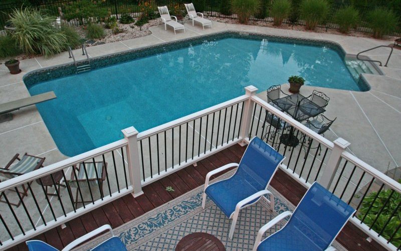 This is a photo of a Lazy L style custom inground swimming pool overlooking from the deck.